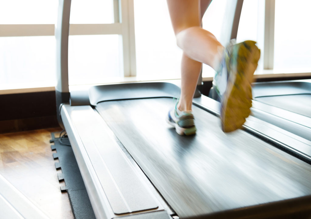 Unrecognizable woman running on treadmills
