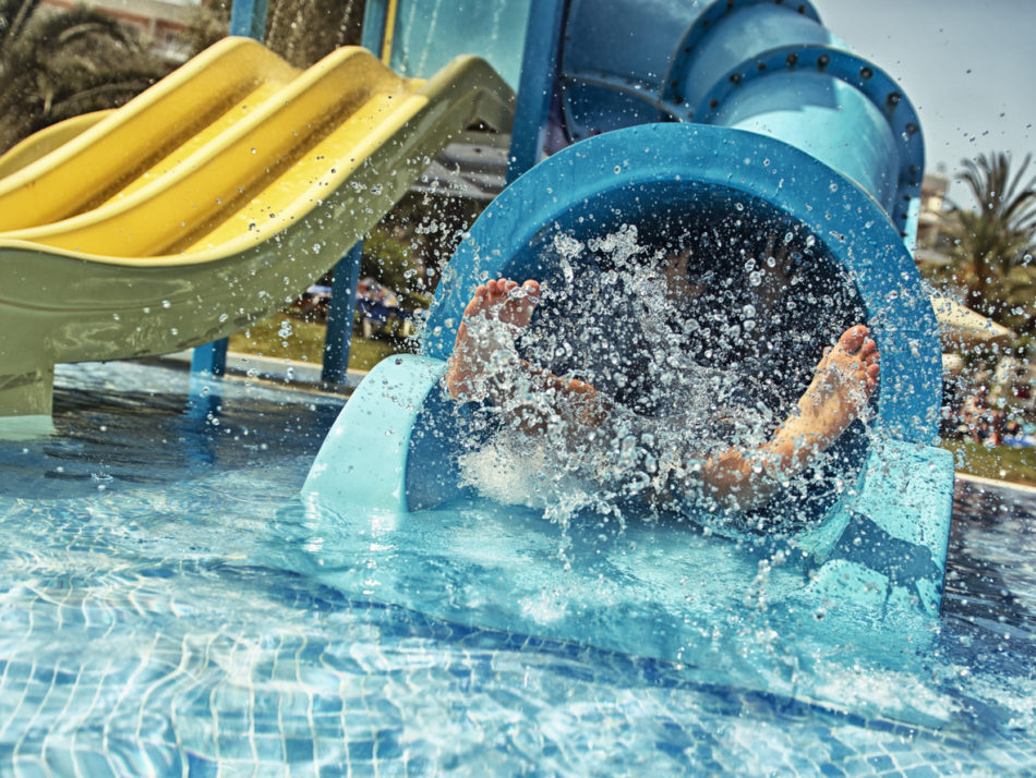 Little girl sliding down waterpark slide