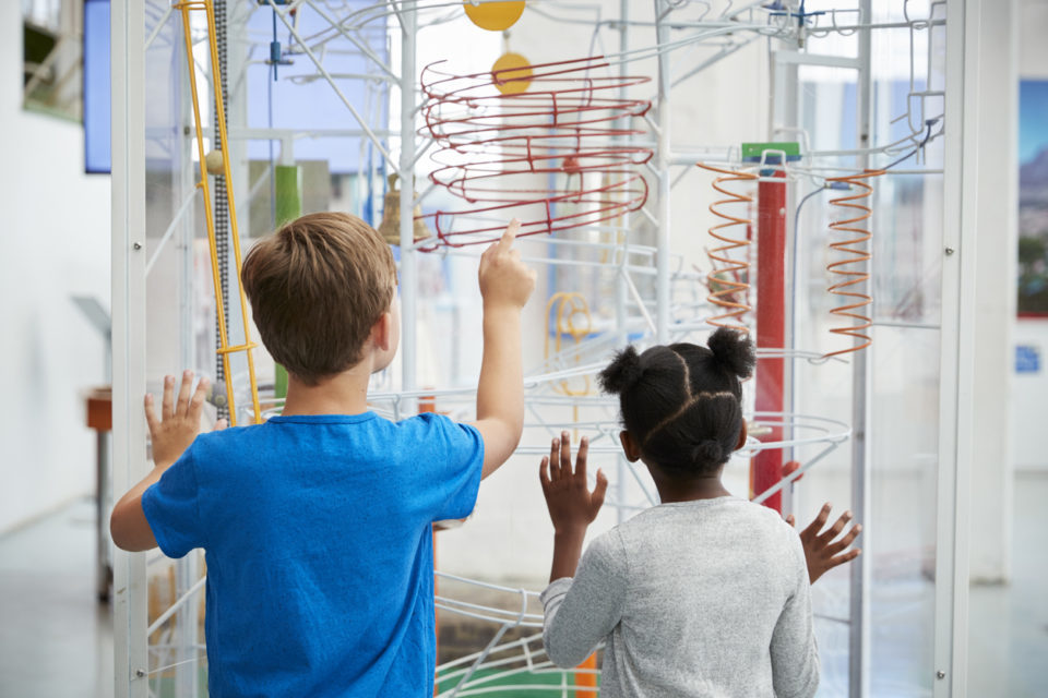 Two kids looking at a science exhibit,