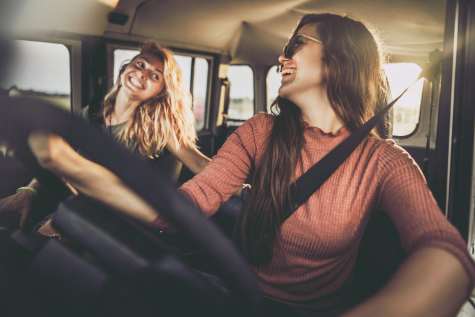 cheerful females taking a drive