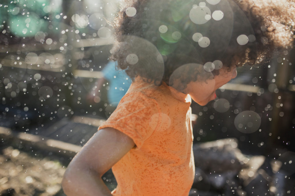 Little Boy Having Fun in the Sprinklers