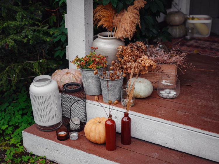 Autumn wooden porch or patio, family heirlooms, with pumpkins and cozy blankets. thanksgiving landscaping decor.